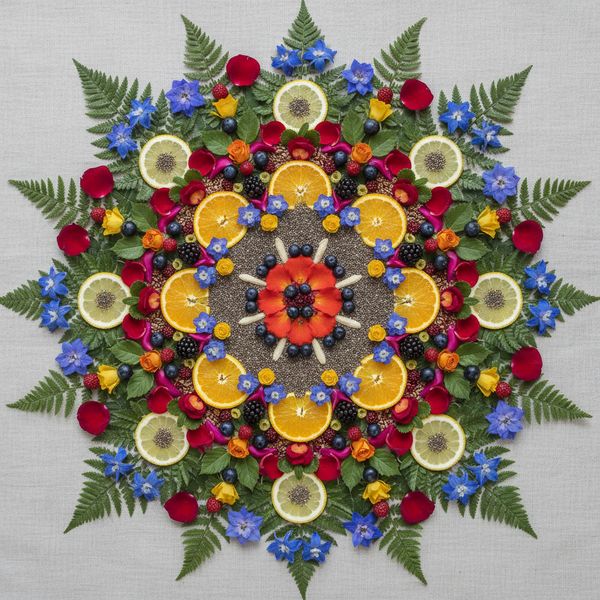 Perfectly symmetrical mandala made entirely of real flowers, petals, leaves, fruits, and seeds in...