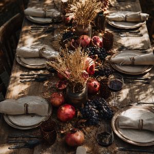 Cinematic overhead shot of a long wooden harvest table se...