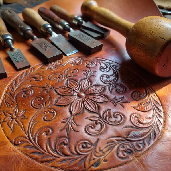 A hyper-realistic close-up of an artisan leatherworker's workbench, featuring a set of vintage st...