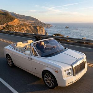 Make a photo of the man driving the car down the Californ...