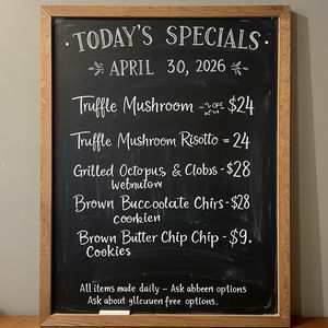 Handwritten-style chalkboard menu in a cozy café, all tex...